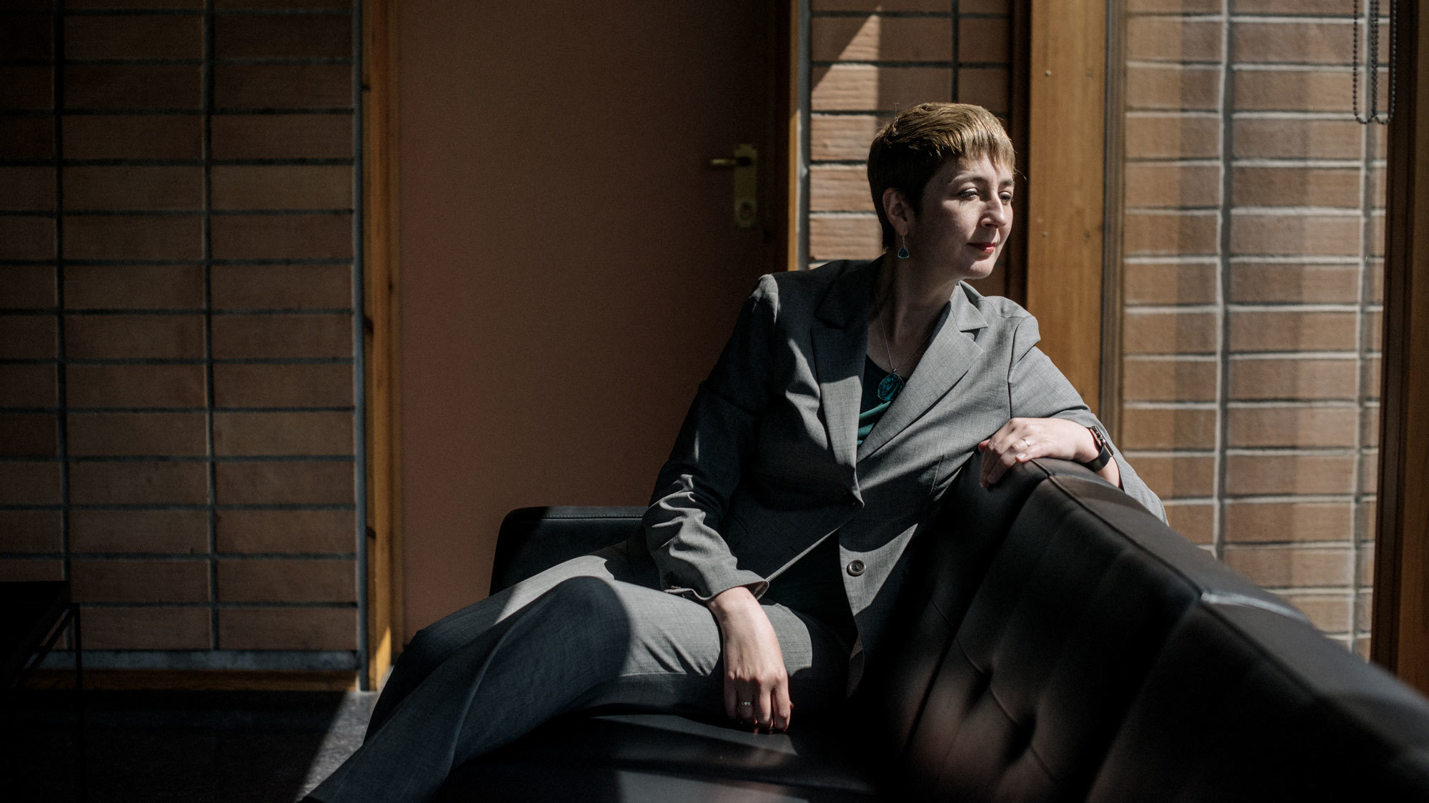 Darla Crispin sitter i sofa og ser ut av vinduet