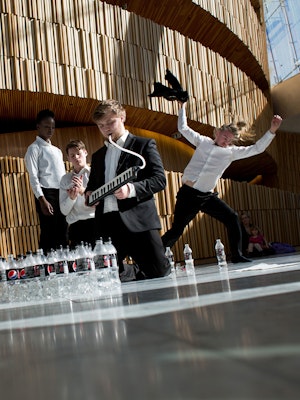 Composition students play melodica and moves around in the foyer of the Opera House.