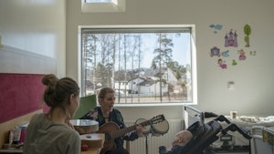 Musikkterapeut Monika Overå med gitar inne på sykehusrom