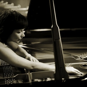Ellen Ugelvik playing the strings at a grand piano