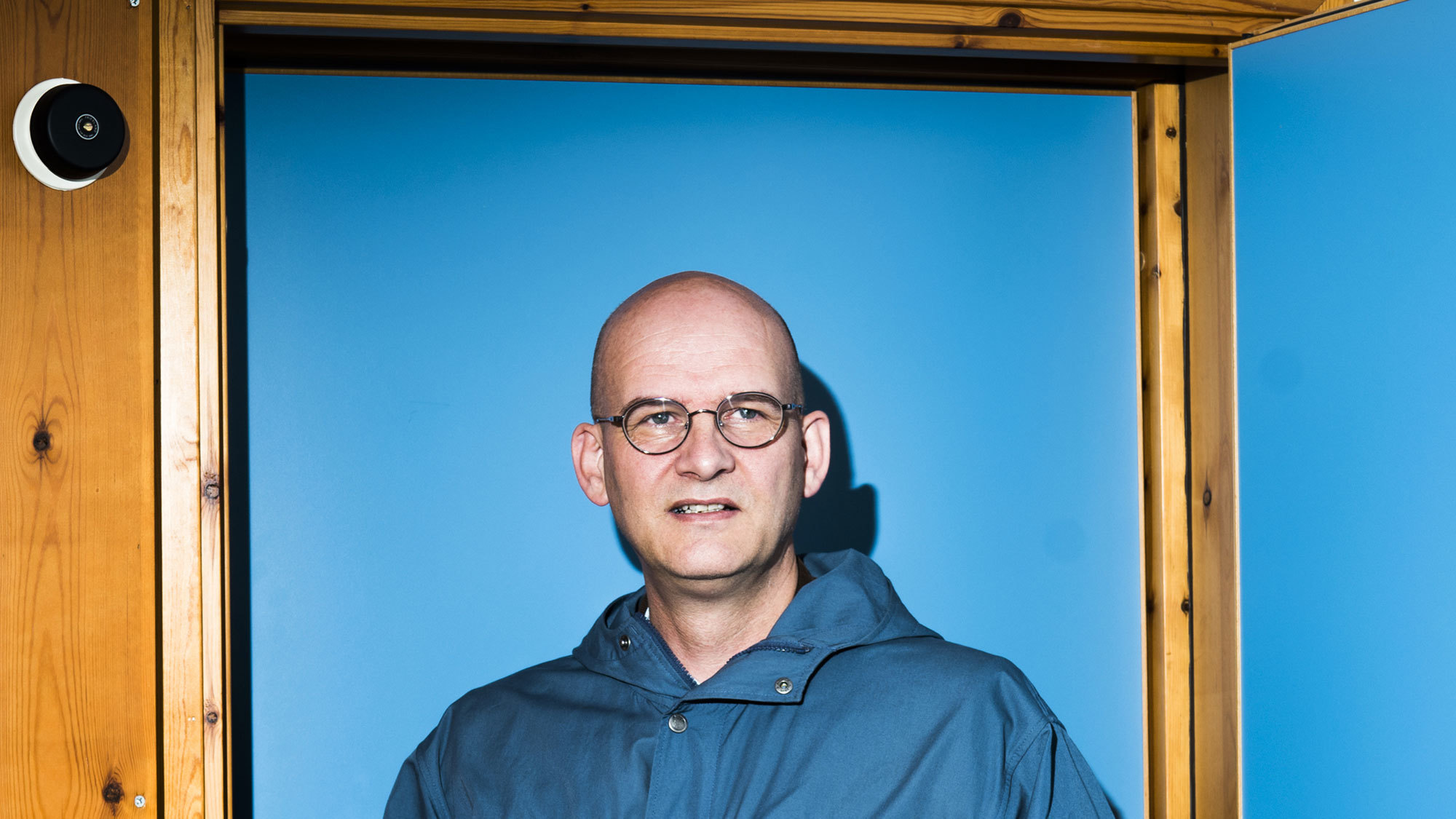 Peter van Tour står foran en knallturkis vegg