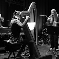Sofie Tollefsbøl står på scenen på Victoria Nasjonal Jazzscene sammen med harpist