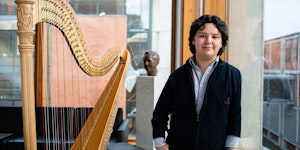 Emmanuel Padilla Holguín står ved siden av harpen sin i Prismerommet