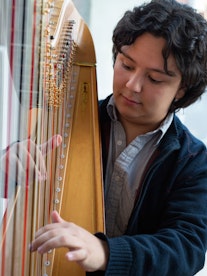 Nærbilde Emmanuel Padilla Holguín som spiller harpe
