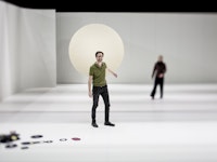 Erik Dæhlin står i et stort hvitt rom med vinyler på gulvet