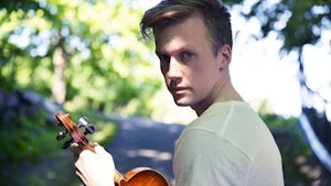 Bjørn Kåre Odde med fiolin foran skogsvei