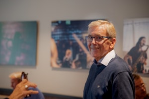 Einar Solbu smilende under NMHs historieprosjektseminar. Bildet er tatt foran de store fotografiene på fellesrommet (rom 139).