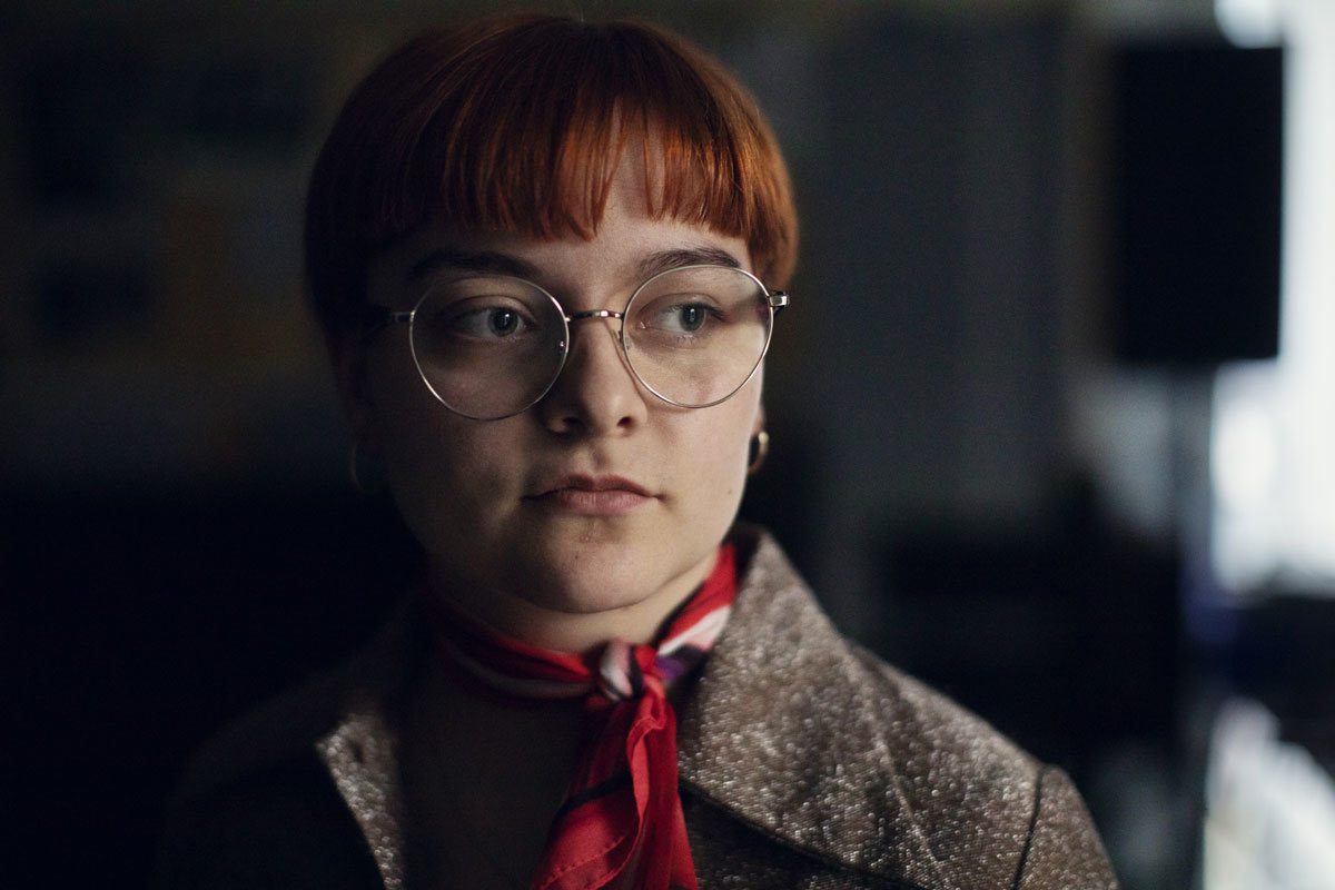 Eir Vatn Strøm in a dark room, looking towards the right.