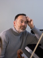 Gunnar Flagstad sitter ved pianoet i Steinway Piano Gallery, sammen med Madelene Berg