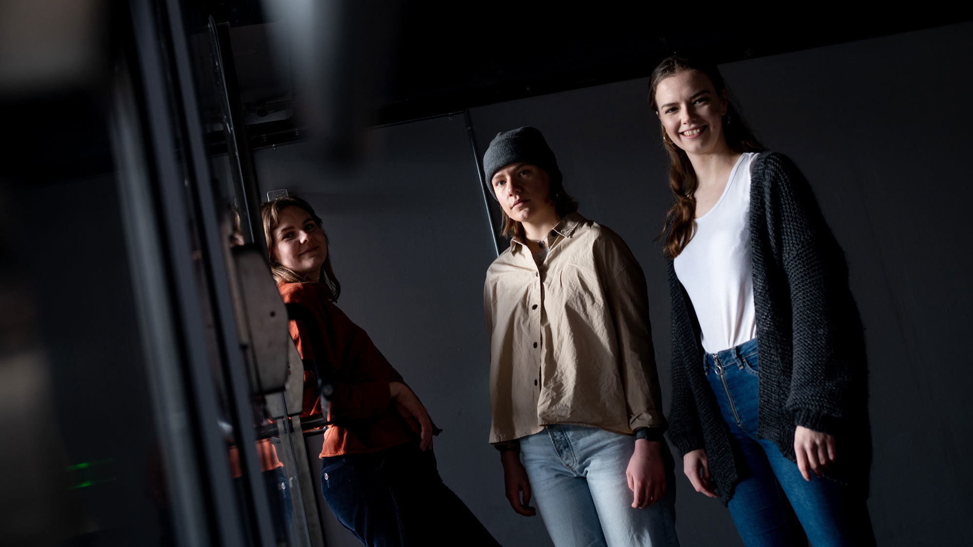 Hedda Hammer Myhre, Maia Viken og Maren Ohm Ballestad står i et mørkt rom
