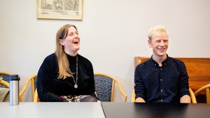 Hugo Gjelsvik Herrman og Guro Utne Salvesen sitter ved et bord og ler