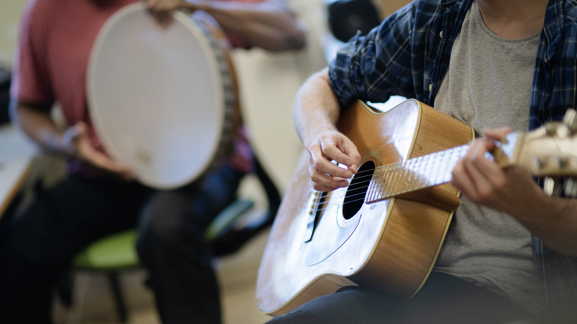 Inmates of Ila Prison playing guitar and drums during a music therapy session.