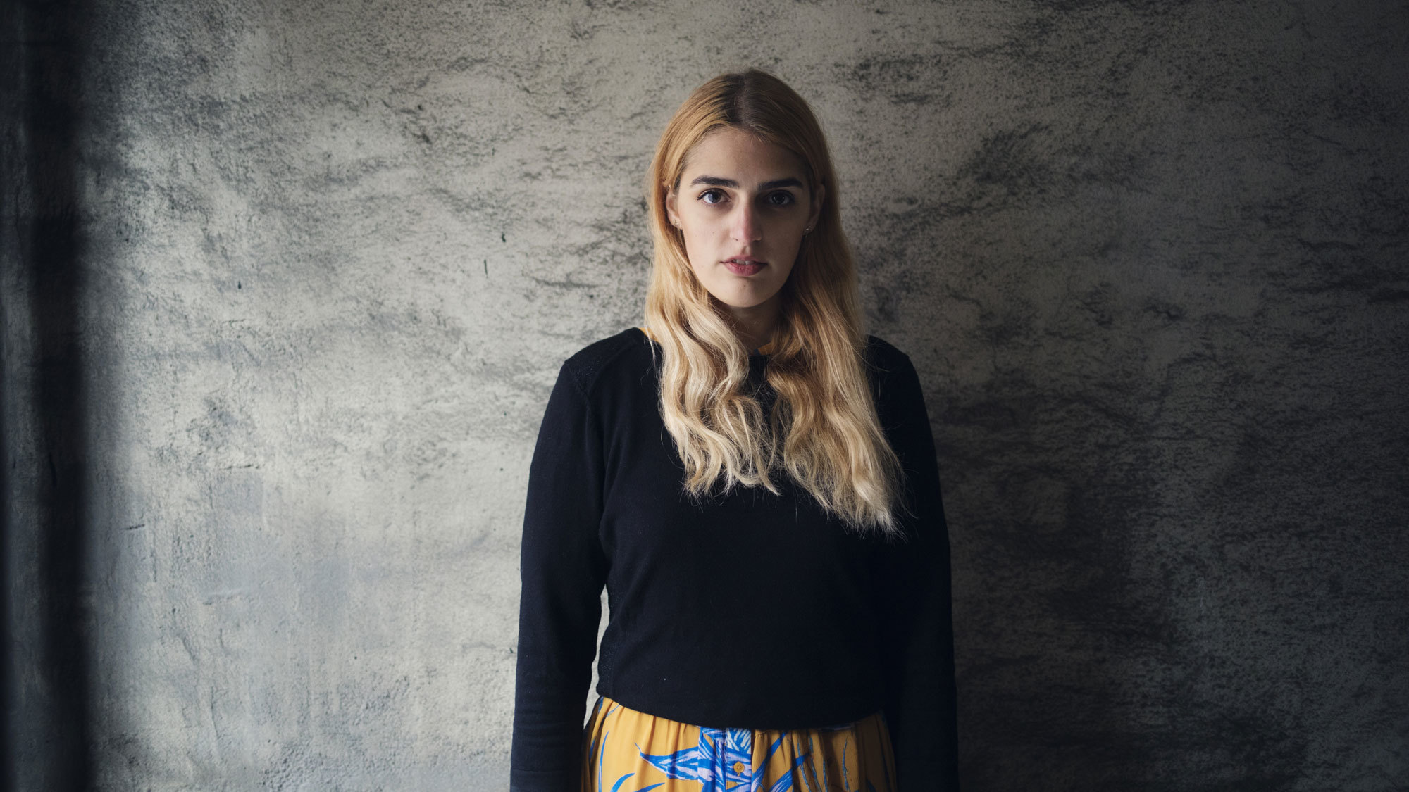 Larissa Terescenko står foran grå vegg og ser inn i kameraet