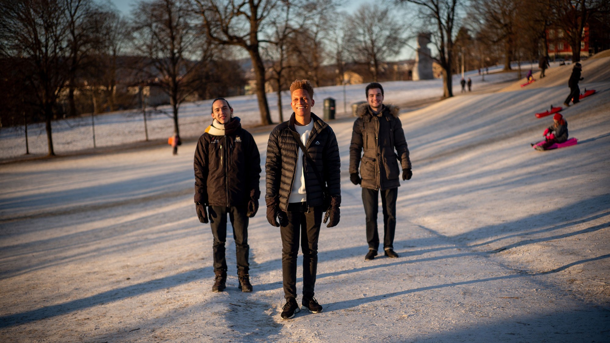 Utvekslingsstudentene Uviwe Caso, Levan Chkhaidze og Eduardo Villamizar står i snødekt park.