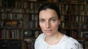 Portrett av Maja Ratkje foran bokhyller