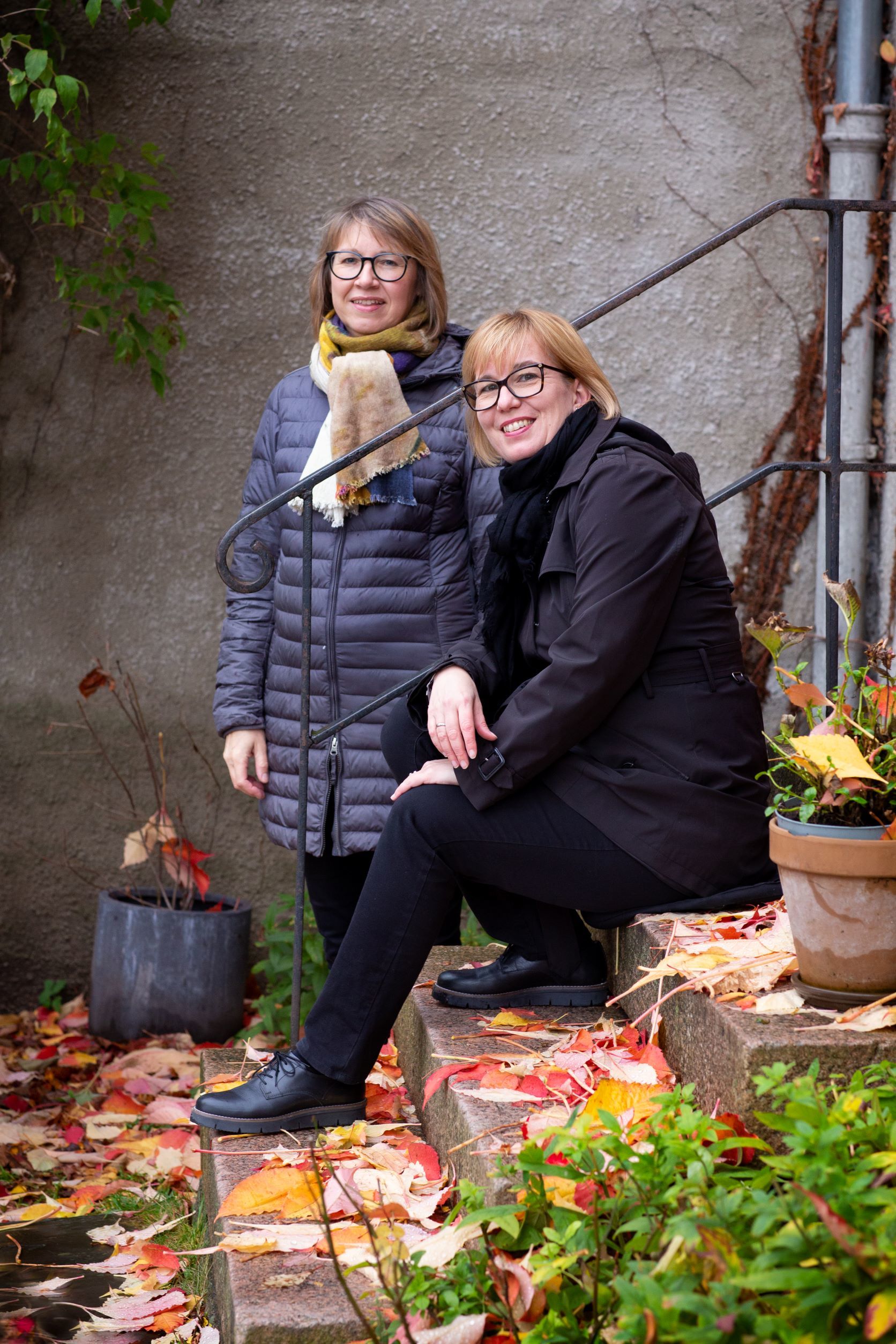 Siw Graabræk Nielsen og Sidsel Karsel sitter/står ved trapp utendørs