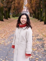 Susanne Trinh, portrett, med trær og gangvei i bakgrunnen