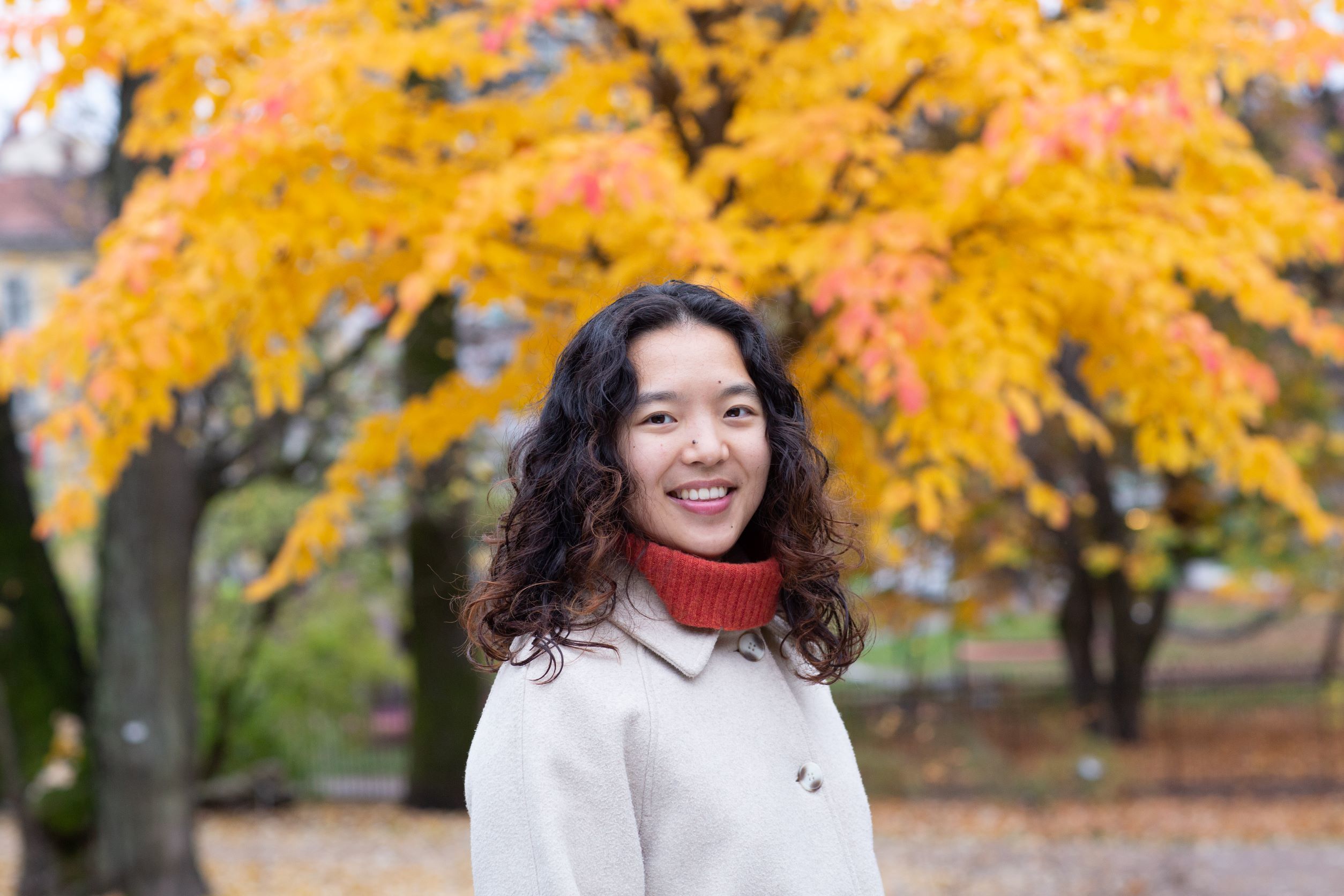 Susanne Trinh, portrett, med høstfargede trær i bakgrunnen