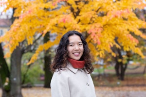 Susanne Trinh, portrett, med høstfargede trær i bakgrunnen