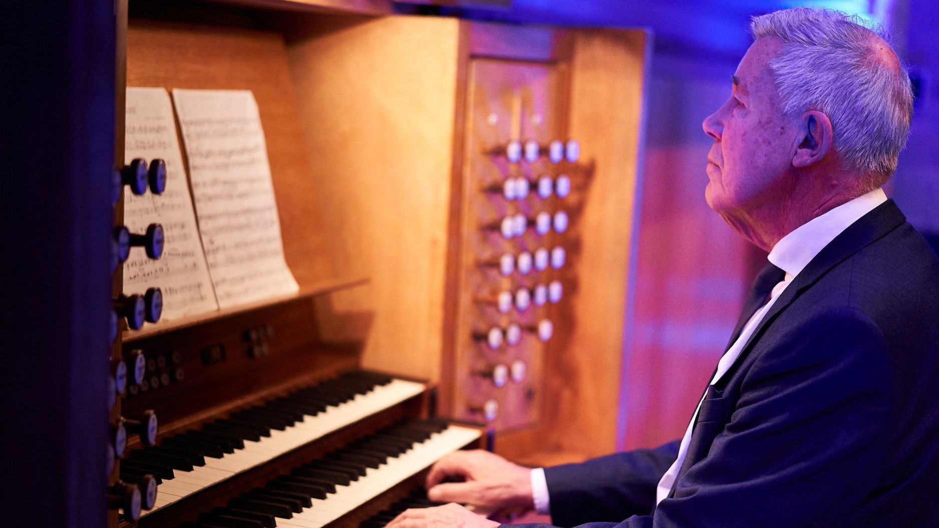 Harald Herresthal sitter ved orgelet og spiller.