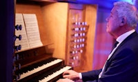 Harald Herresthal sitter ved orgelet og spiller.