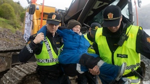 Hilja Løvvik blir båret vekk fra en gravemaskin av politiet.