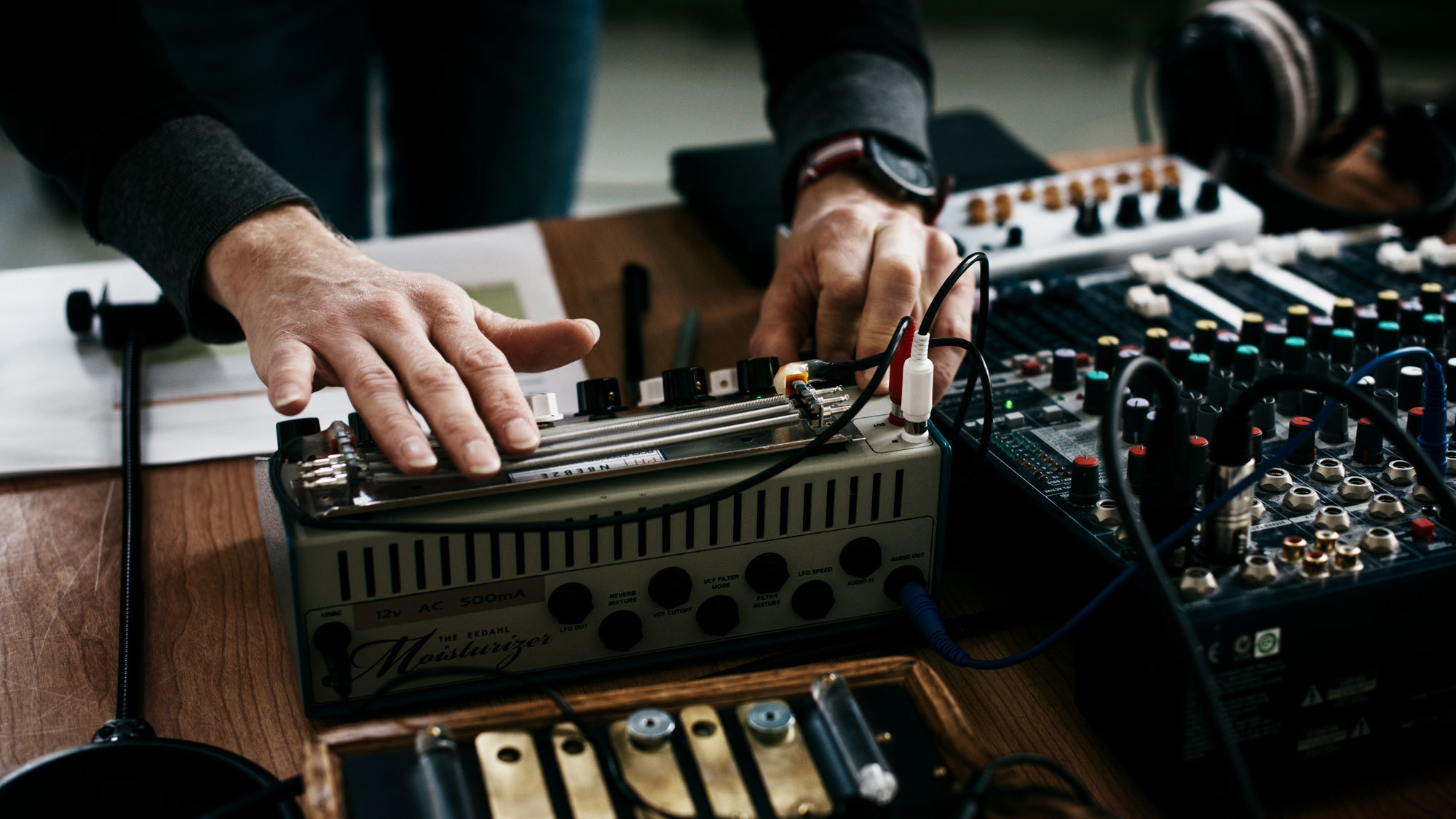 Hender som jobber på et miksebord.