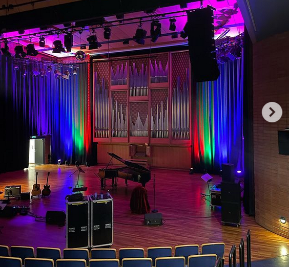 Lindemansalen med regnbuefargede lys rundt orgelet.
