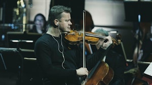 Peter Herresthal spiller fiolin på konsert foran et ensemble med strykere.