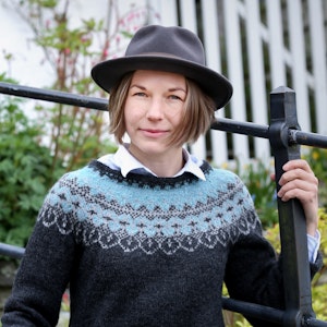 Portrett av Rebecka Sofia Ahvenniemi med hatt foran et smijernsgjerde.