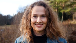 Portrett av Stine Camilla Blichfeldt-Ærø som står foran trær i høstvær.