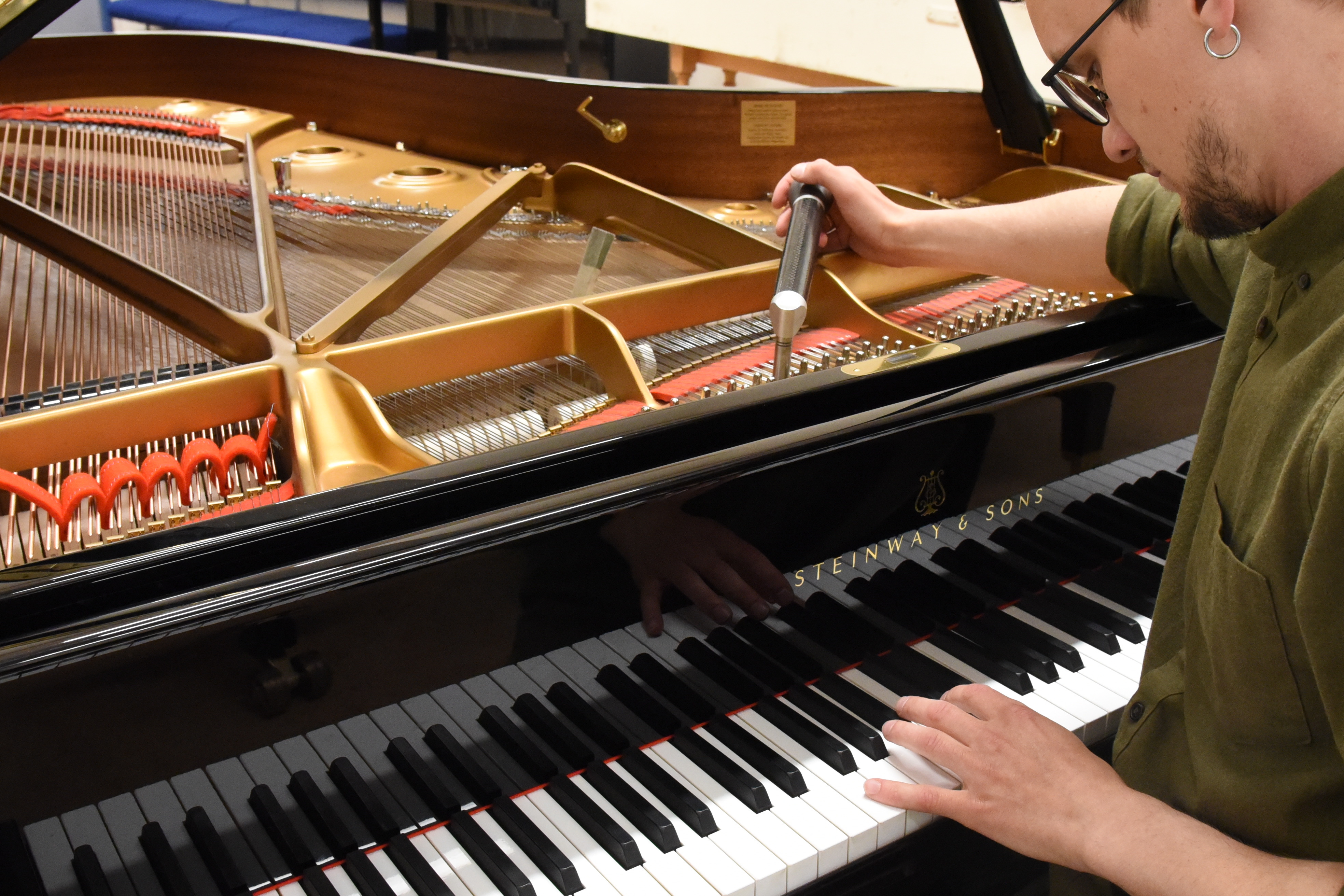 Torkil Rødvand sitter ved flygel, og spiller med den ene hånden