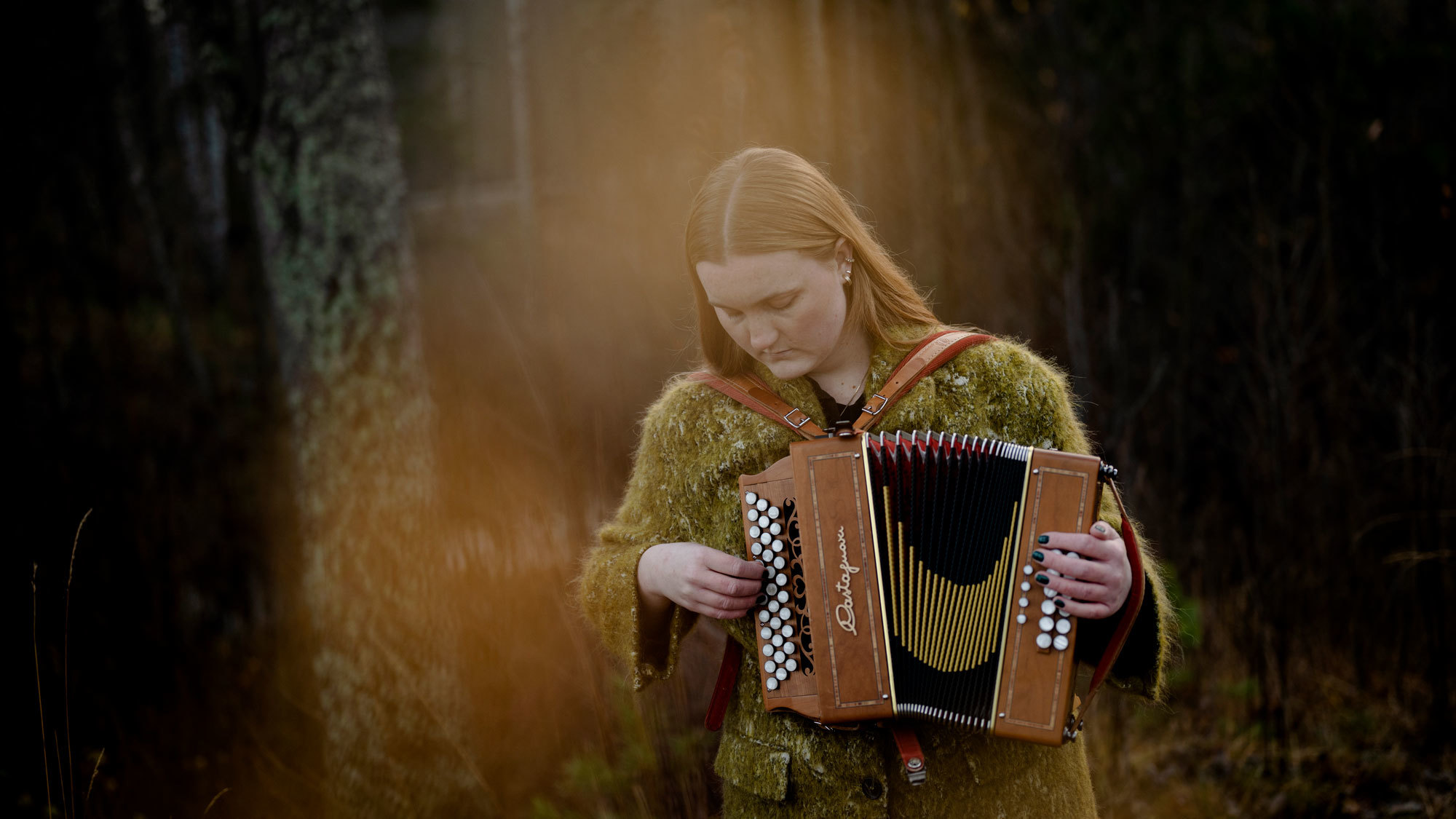 Amalie Kinsarvik Tvilde spiller torader i skogen, med litt uklar forgrunn.