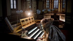 Liv Kristin Holmberg sitter ved orgelet i en kirke og spiller.