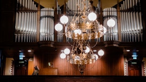 Liv Kristin Holmberg sitter ved orgelet i en kirke og spiller. Orgelet fyller hele bildet.
