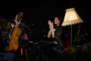 Jelena Golubovic sitter bak et piano og klapper, på scenen på Chat Noir.