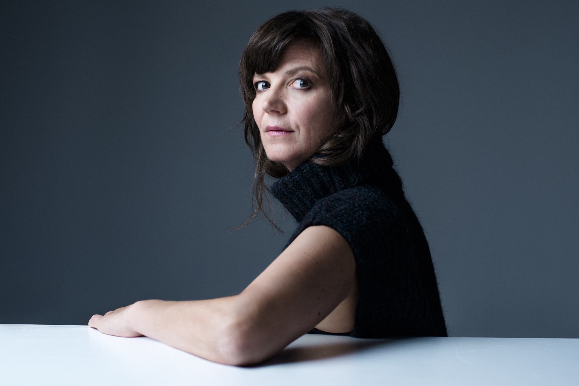 Portrett av Ellen Ugelvik som lener seg på et bord.