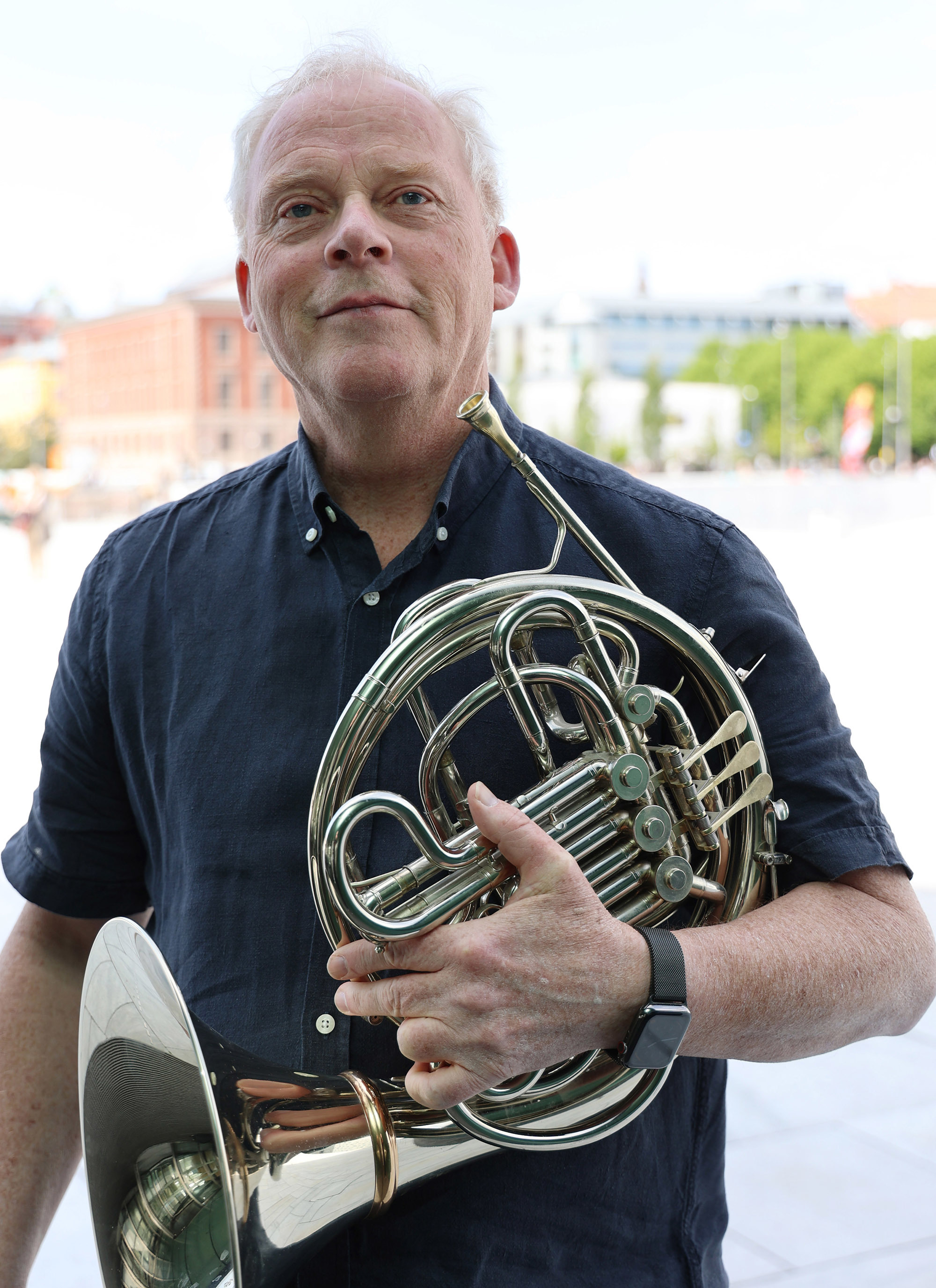 Runar Tafjord i halvfigur forfra utendørs. Holder hornet i venstre hånd. Ser rett fram og smiler.