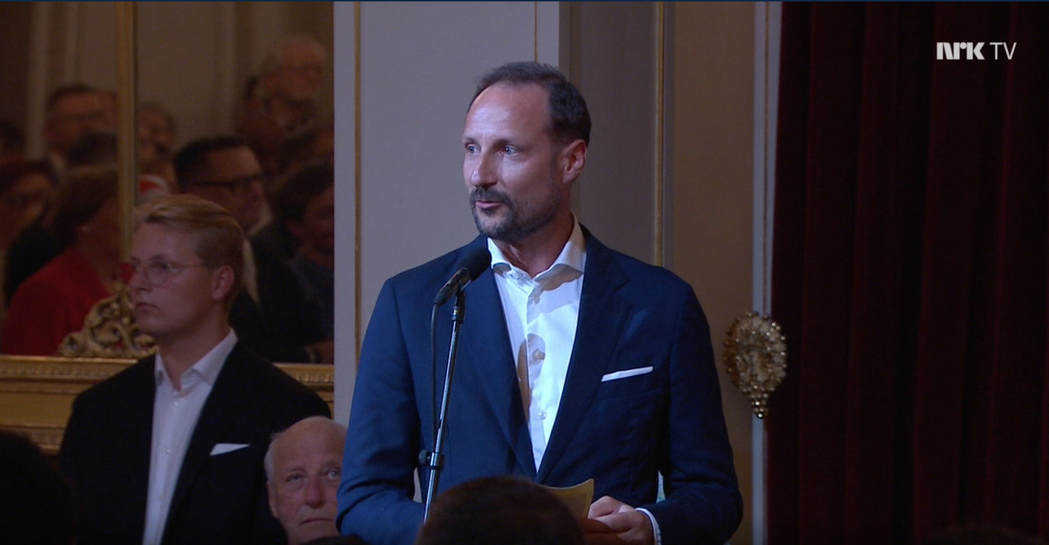 Kronprins Haakon fotografert via en TV-skjerm