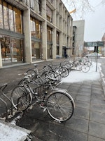 Sykkelstativet foran NMH. Få sykler. Vinter og litt snø.