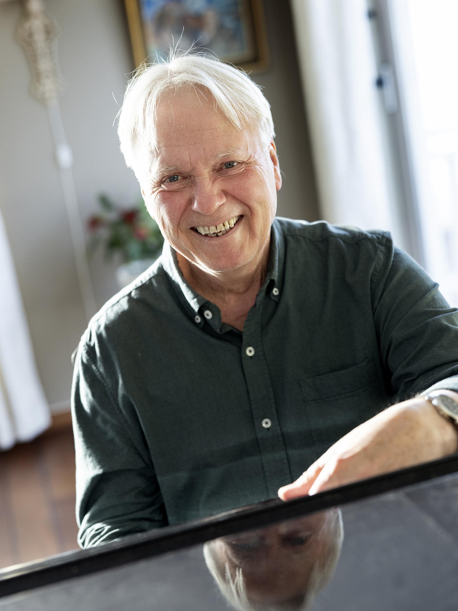 Jens Harald Bratlie smiler bredt bak flygelet.