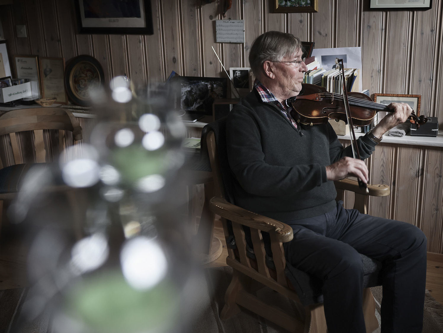 Sven Nyhus spiller fele med et uklart glass i forgrunnen.