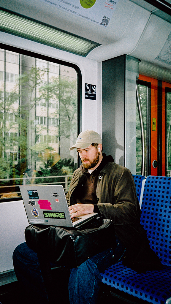 Tobias Grønborg sitter på toget med laptop i fanget.
