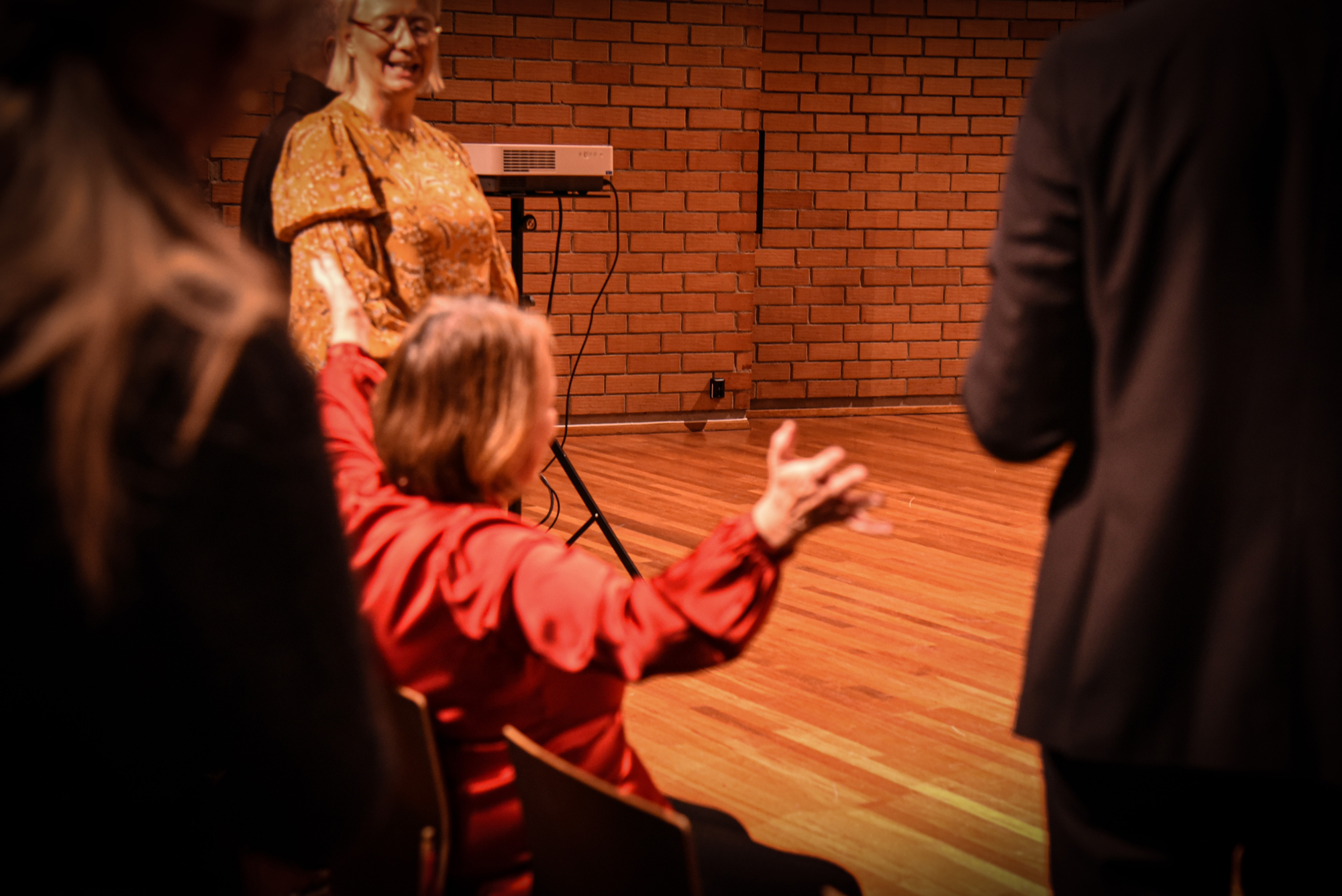 Hilde Ringlund sitter i Lindemansalen og åpner armene mot musikerne på scenen.