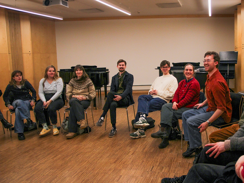 Studenter i ring på stoler i et klasserom. God stemnning.