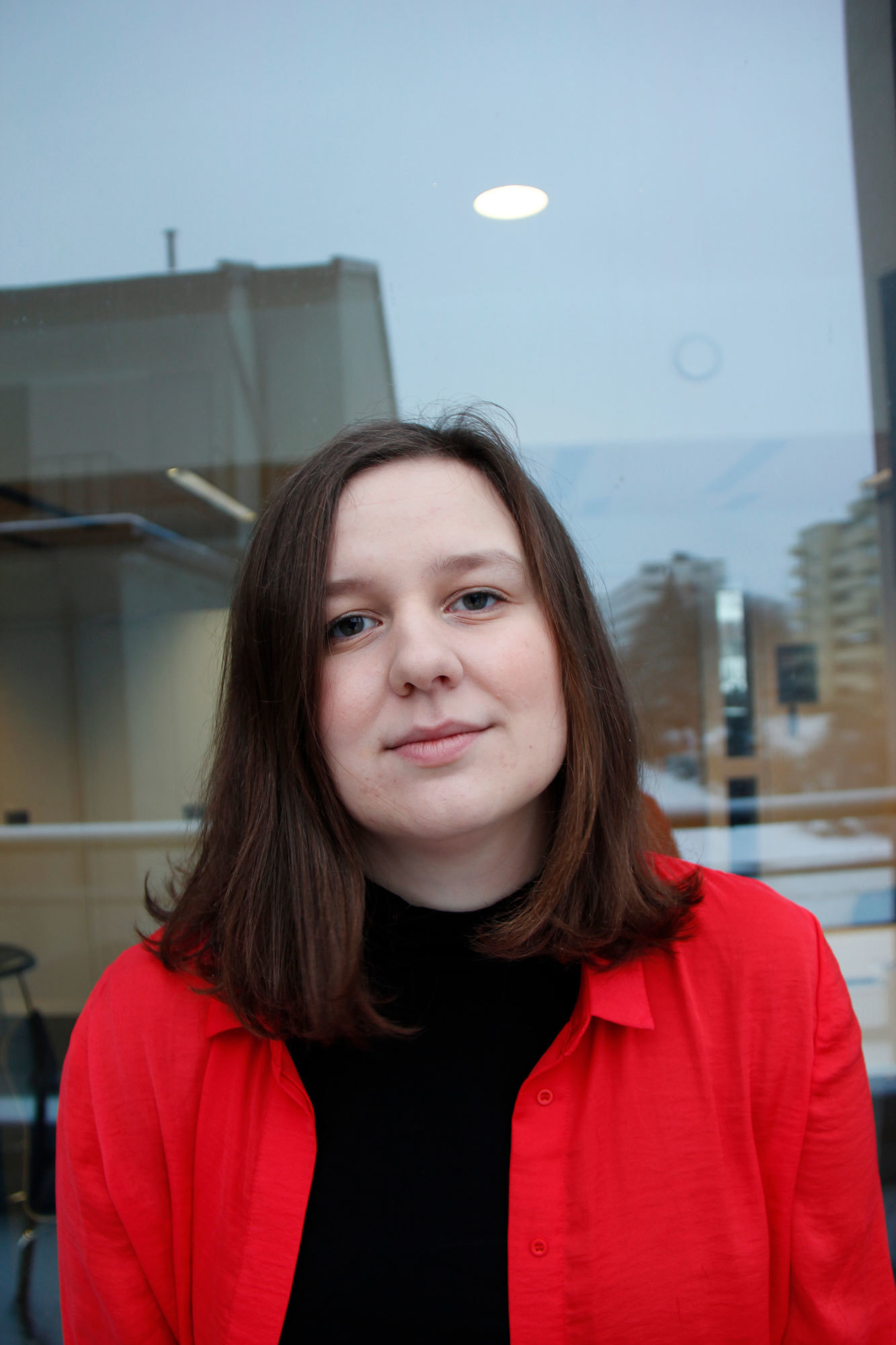 Portrett av Olivia Køppe Christoffersen i knall-rød skjorte