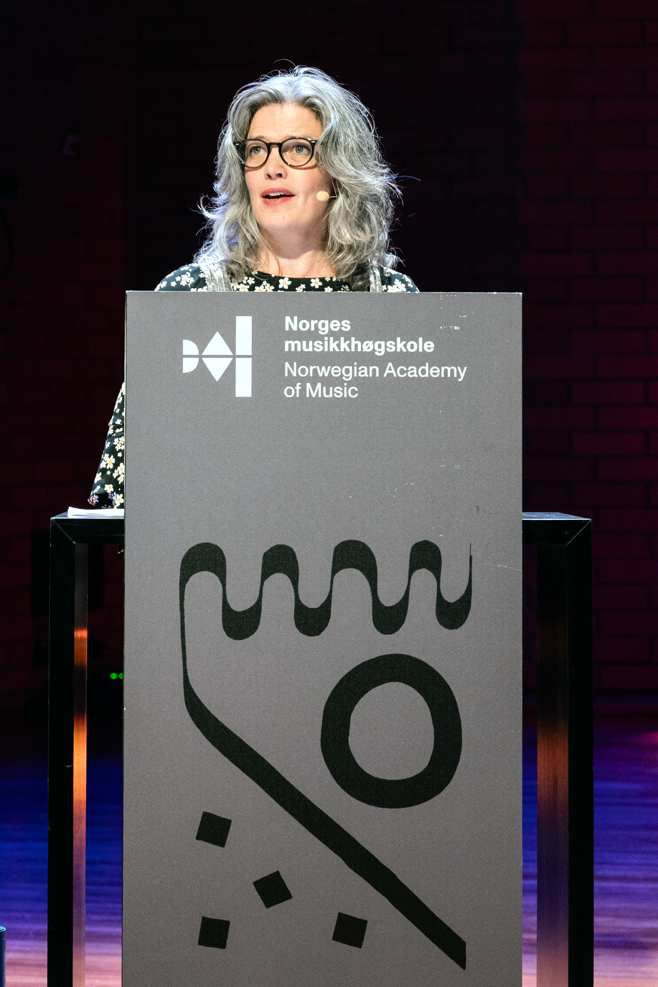 Rektor Astrid Kvalbein holder tale ved et podium.