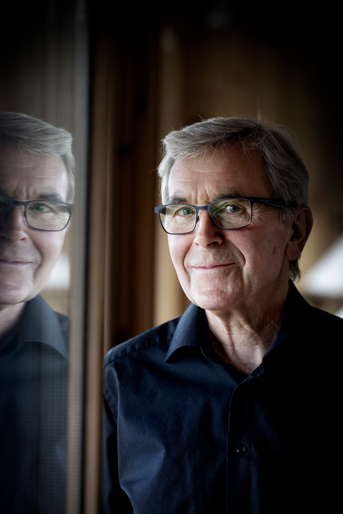 Portrett av Einar Solbu ved et vindu.