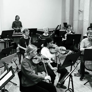 sort hvitt bilde av orkester som øver