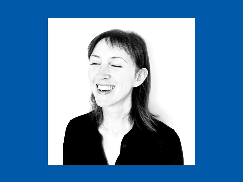 Sorthvitt bilde av leende kvinne innrammet i blått.